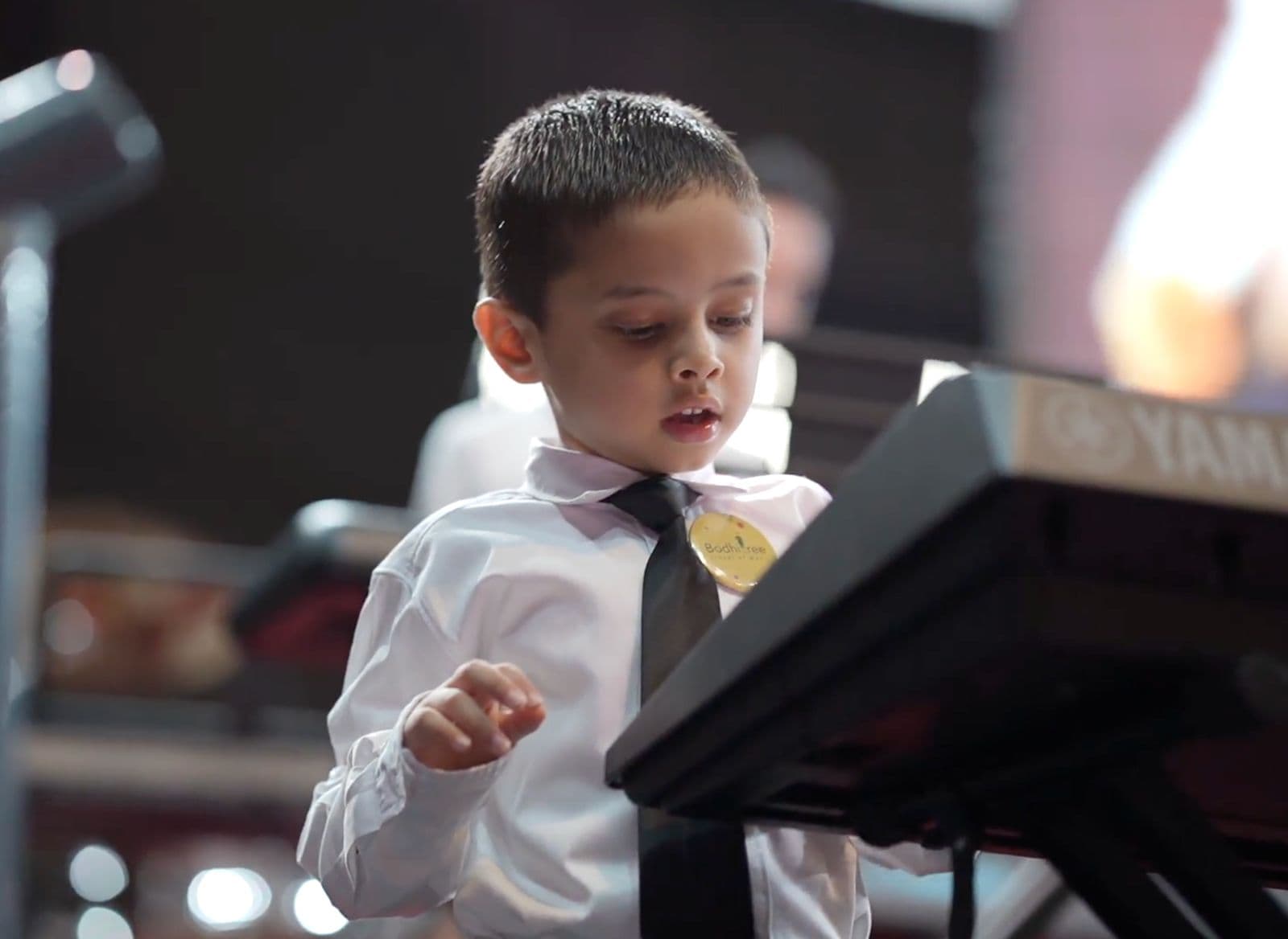 A young BodhiTree student performing on keyboard at a recital